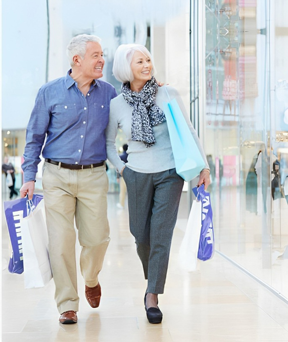 old couple walking through shopping centre